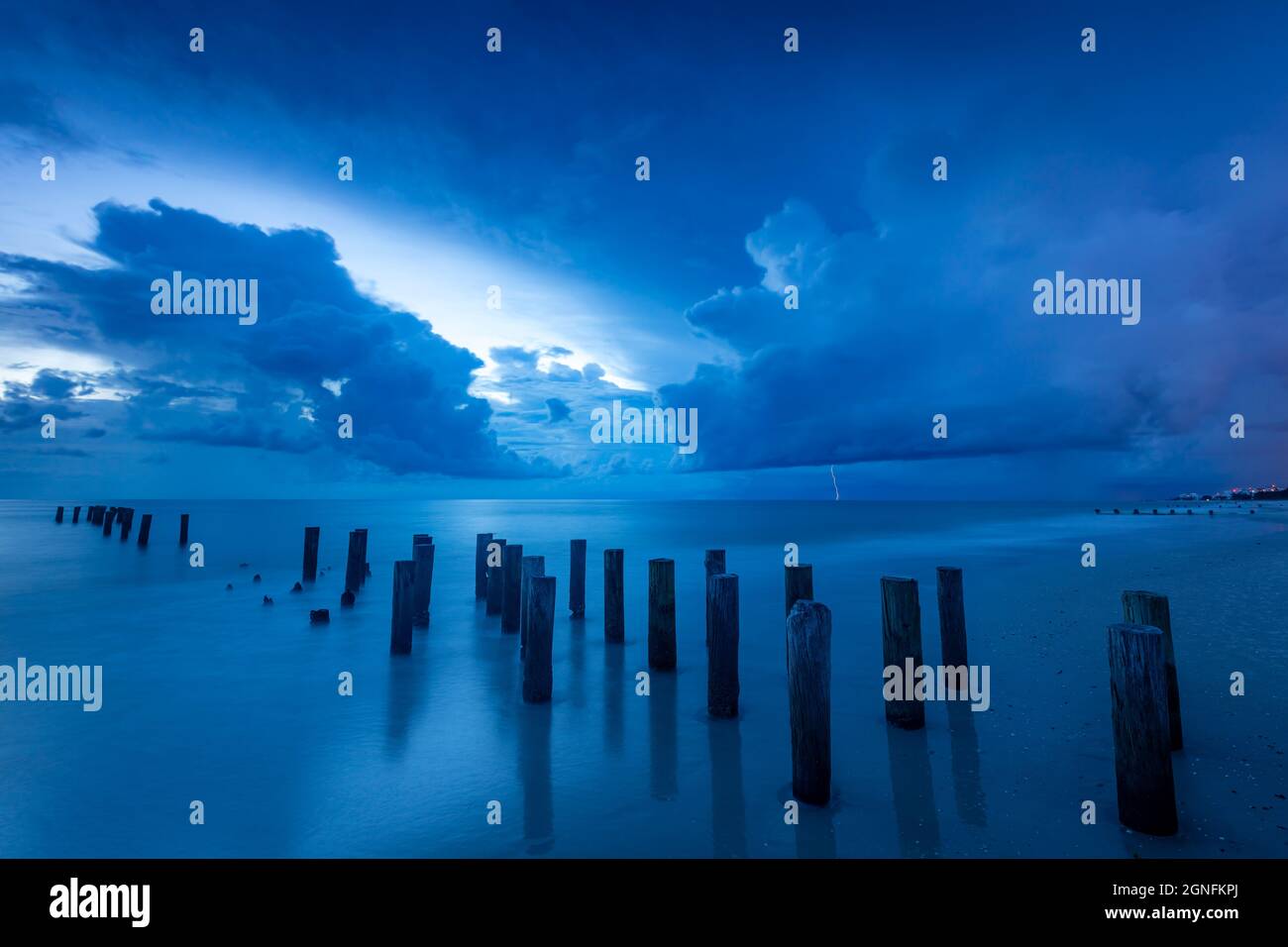 Dämmerung über alten Pier Pilings entlang des Golfs von Mexiko in Naples, Florida, USA Stockfoto