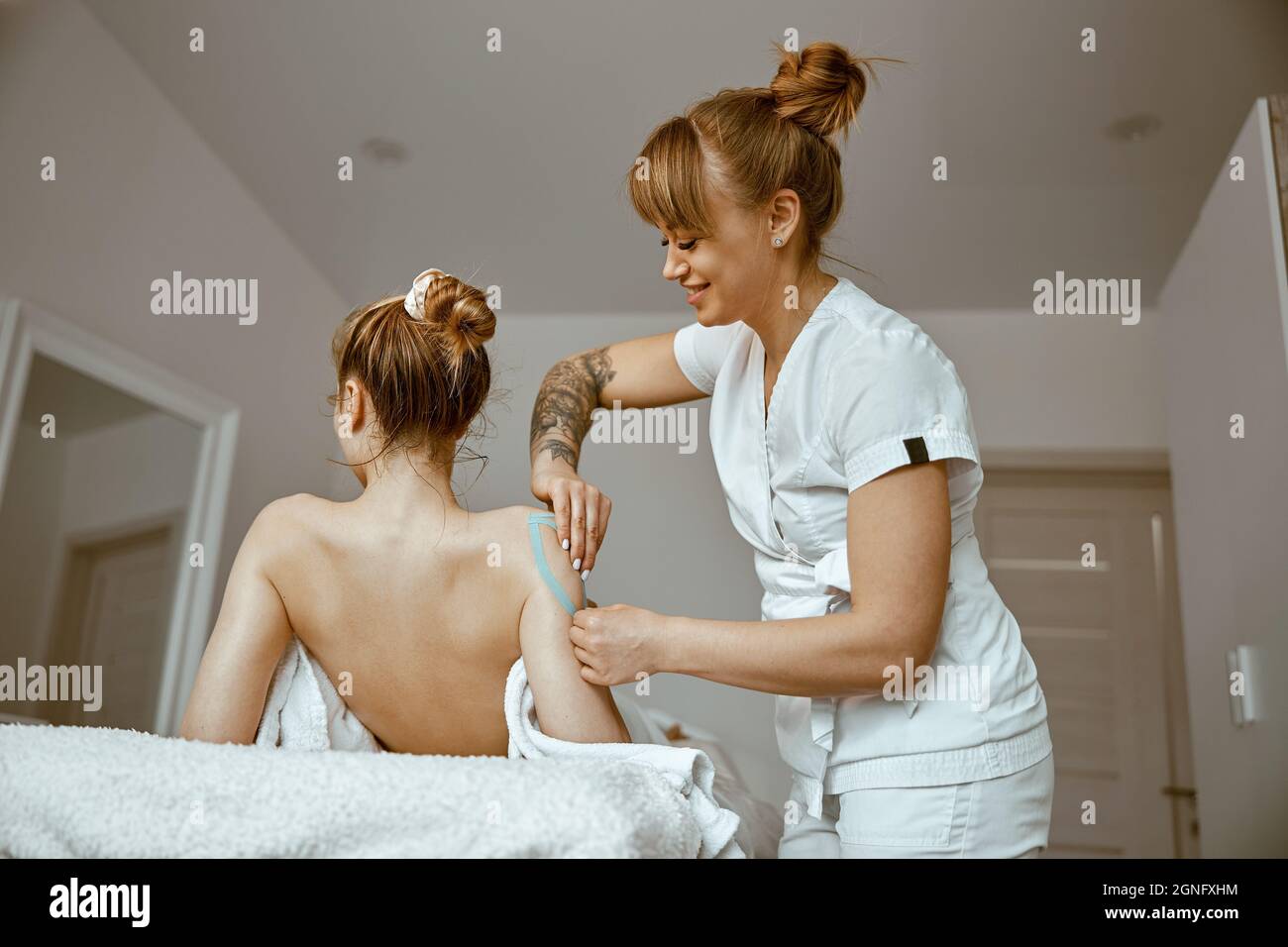 Eine selbstbewusste Ärztin führt ein Taping-Verfahren in der Modenr-Behandlungskammer durch Stockfoto