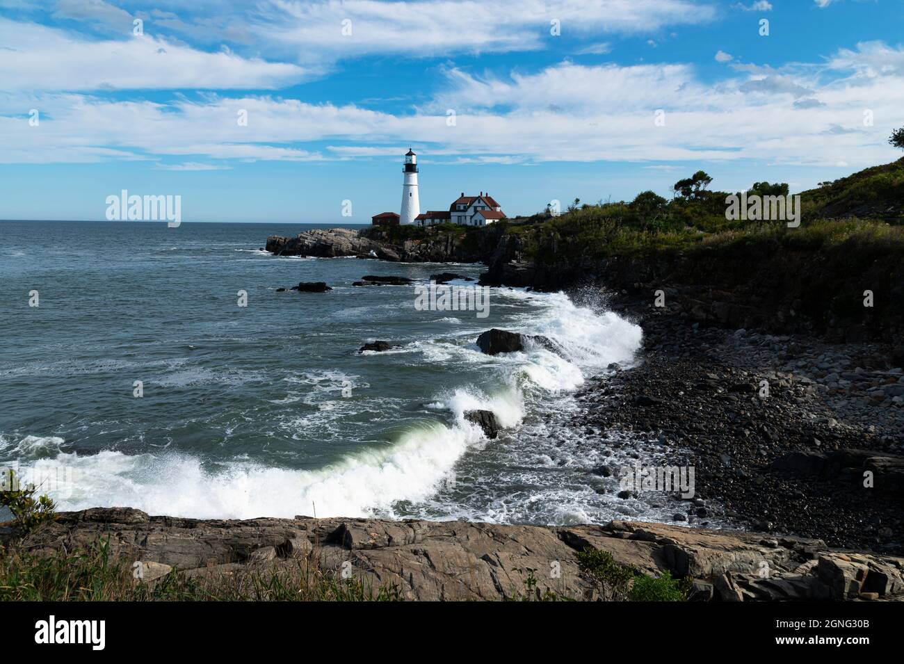 Bei Flut stürzen die Wellen über den felsigen Strand am Portland Head Leuchtturm in Maine. Es ist das älteste Leuchtfeuer in Maine. Stockfoto