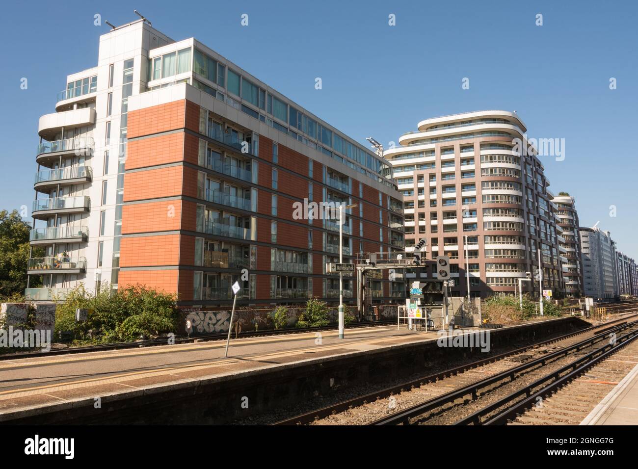 Wohnhäuser umgeben menschenleere Plattformen am Bahnhof Battersea Park, London, England, Großbritannien Stockfoto