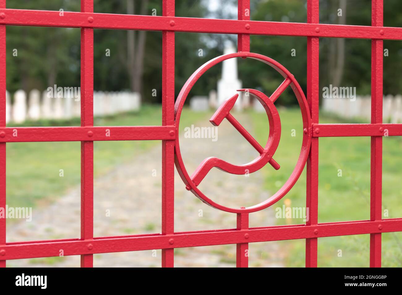 Hammer und Sichel , das Wappen der ehemaligen Sowjetunion am Tor eines Friedhofs für gefallene Soldaten des Zweiten Weltkriegs in Deutschland Stockfoto
