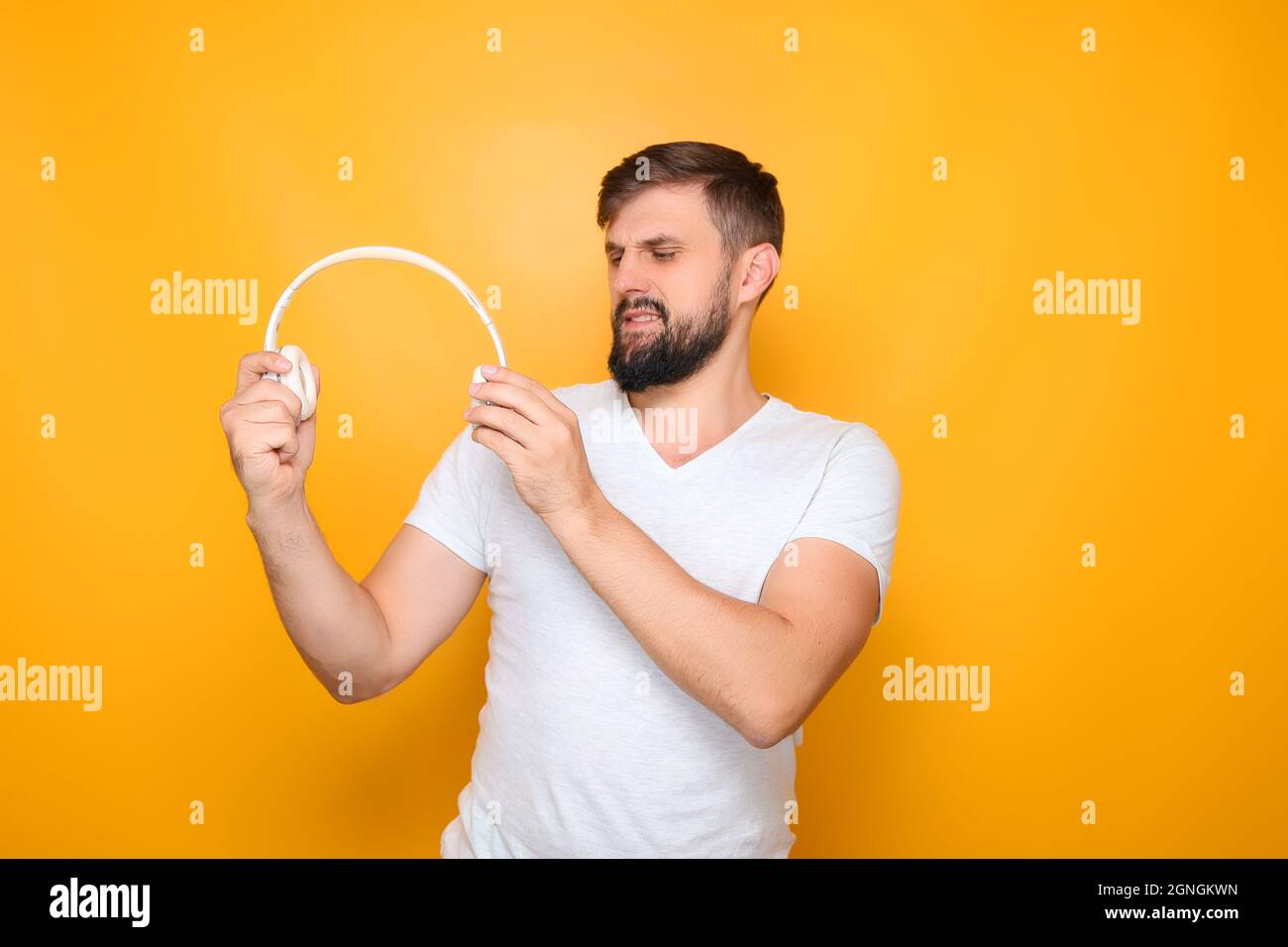 Der Mann streut die Kopfhörer aus, um sie auf den Kopf zu stellen. Stockfoto