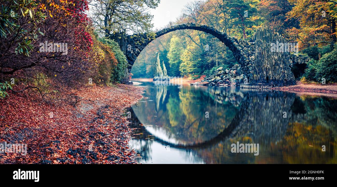 Panorama-Morgenlandschaft von Azalea und Rhododendron Park Kromlau, Deutschland, Europa. Malerisches Herbstpanorama der Rakotz-Brücke (Rakotzbrucke, Devil's Stockfoto