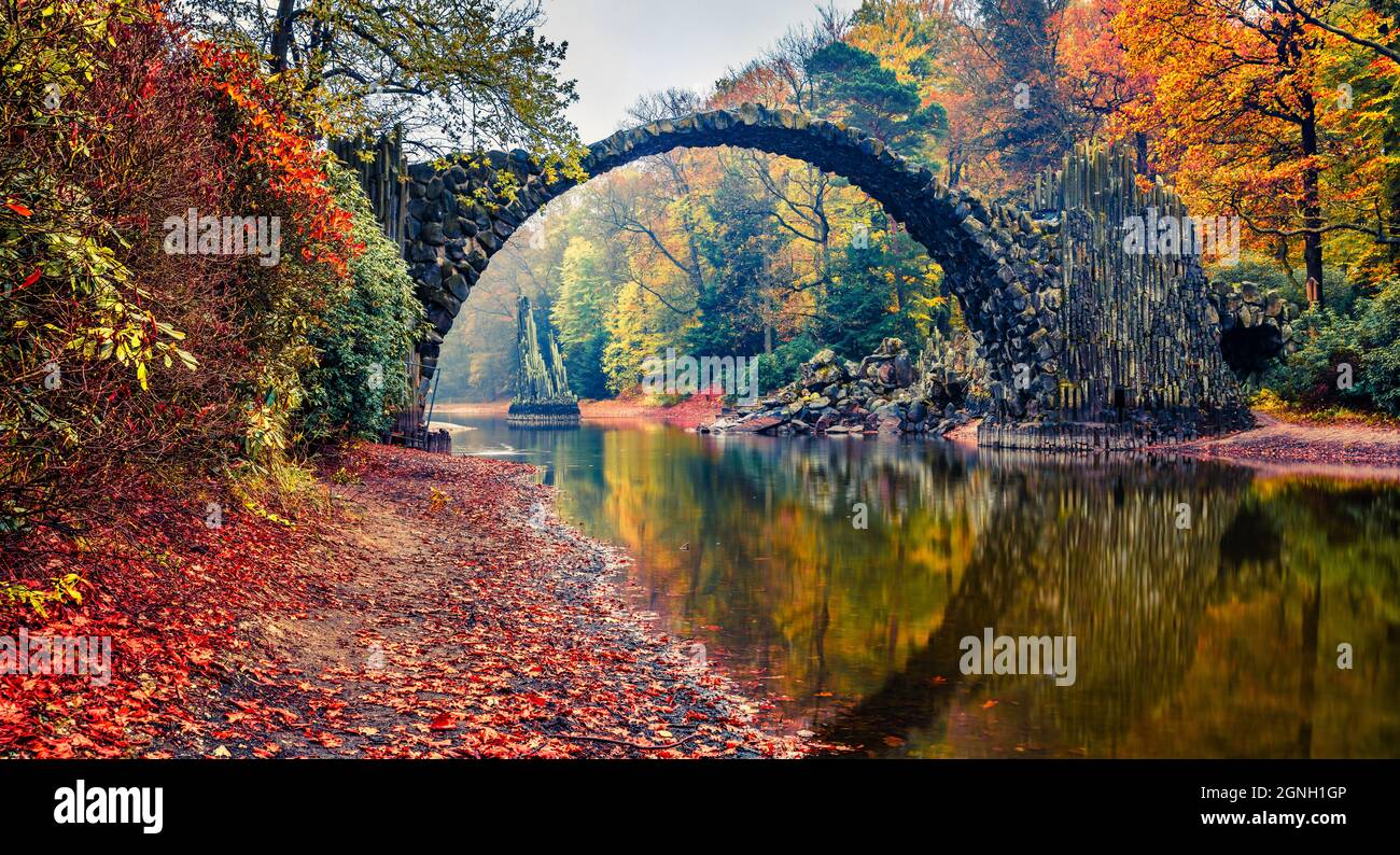 Panorama-Morgenlandschaft von Azalea und Rhododendron Park Kromlau, Deutschland, Europa. Malerisches Herbstpanorama der Rakotz-Brücke (Rakotzbrucke, Devil's Stockfoto