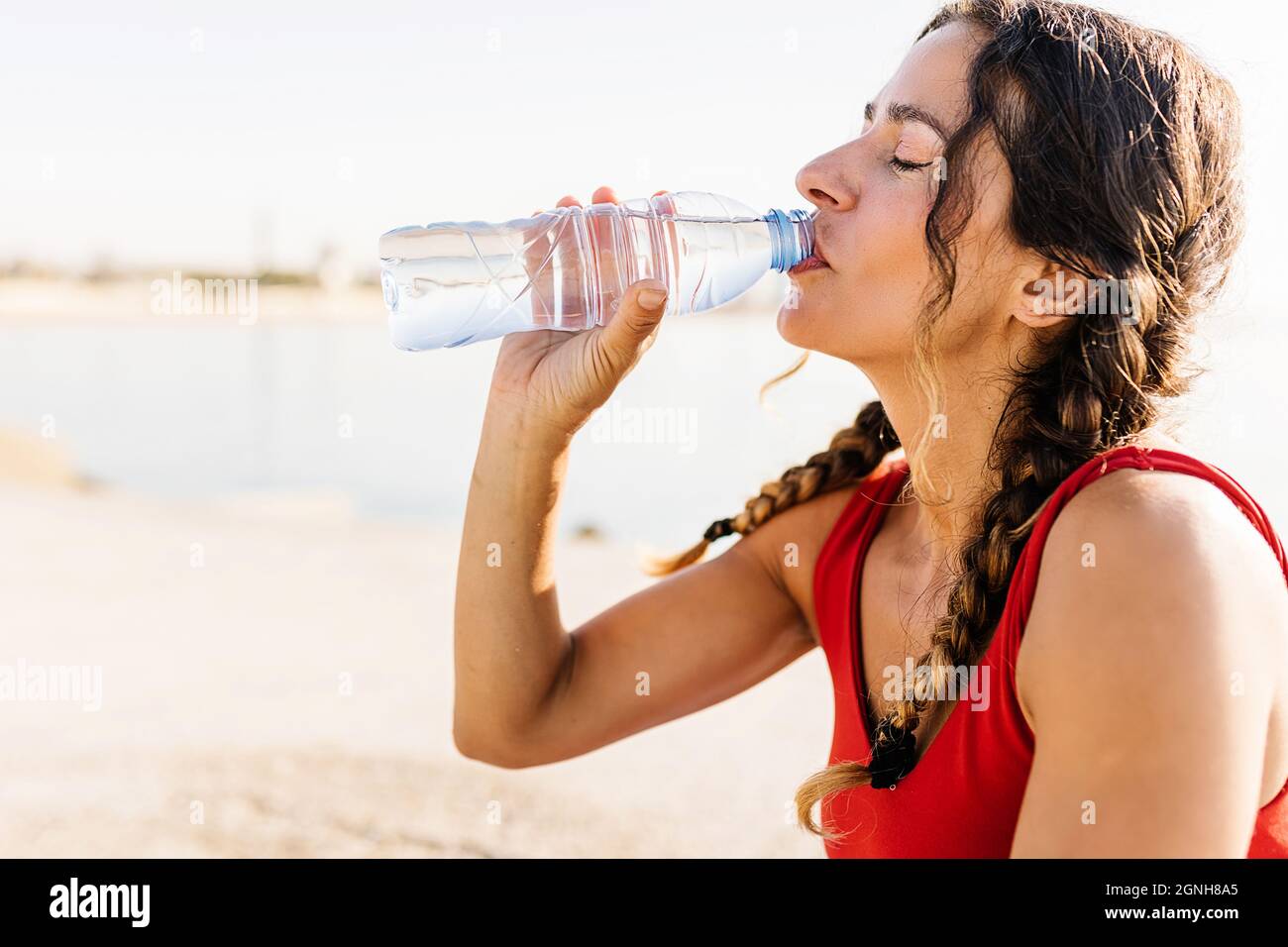 Fitness Frau Trinkwasser aus der Flasche nach dem Training am Morgen Stockfoto