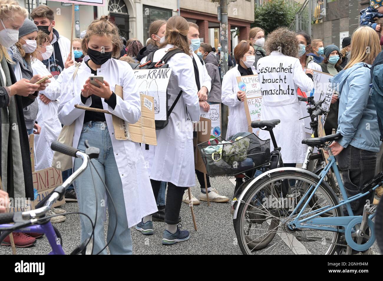 Lübeck, 24. September 2021: Junge Menschen aus dem Medizinbereich mit deutschen Slogans auf ihren weißen Mänteln, das heißt: Gesundheit braucht Klima Stockfoto