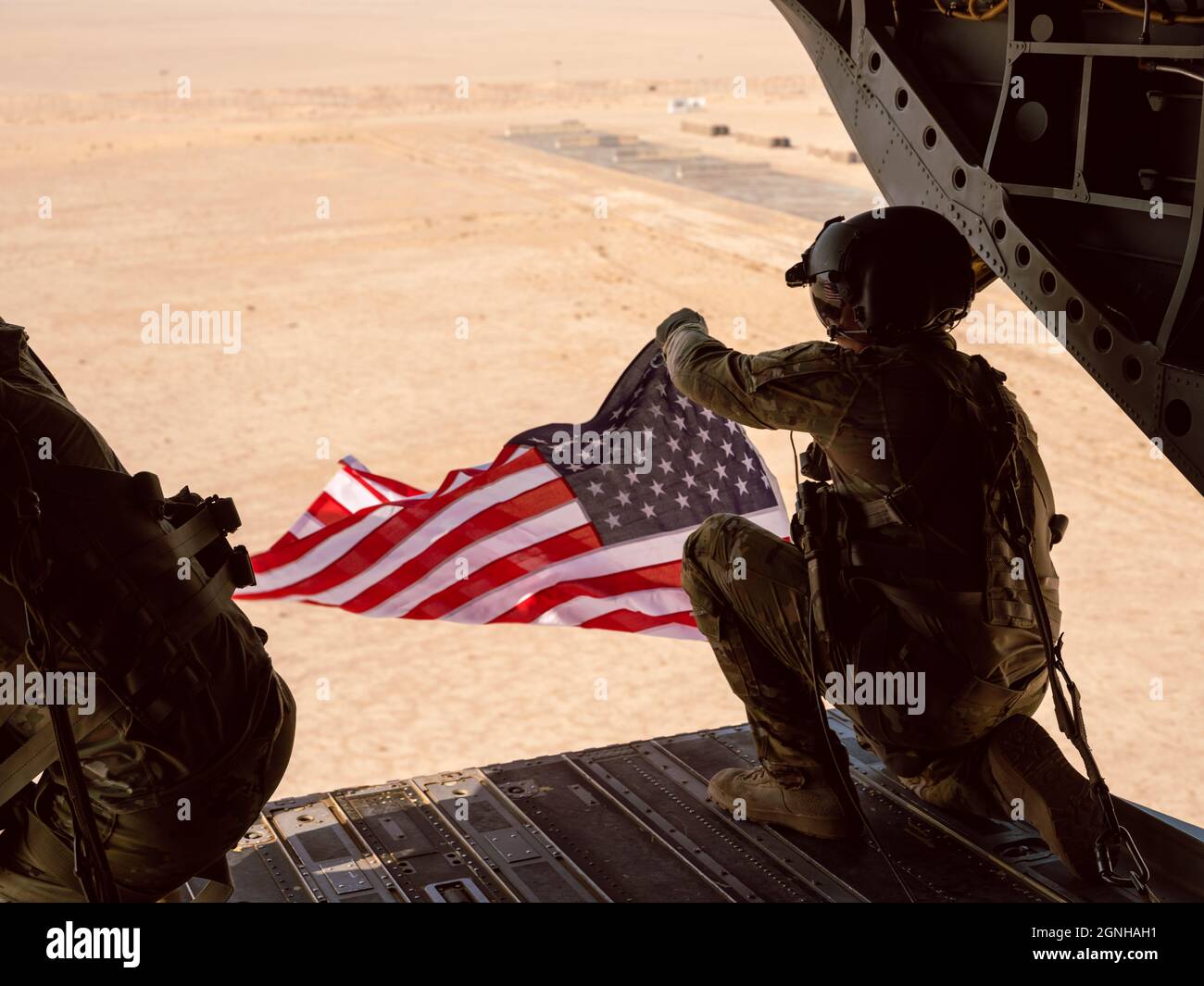 Zwei Mitglieder der Flight Crew von B Co. 640. ASB fliegen amerikanische Flaggen während eines Orientierungsfluges auf einem CH-47 Chinook, während sie mit der 40. CAB nach Camp Buehring, Kuwait, zur Unterstützung der Operation Inhärent Resolve eingesetzt werden. | US Army National Guard Foto von 2LT. Kyle Gallagher Stockfoto
