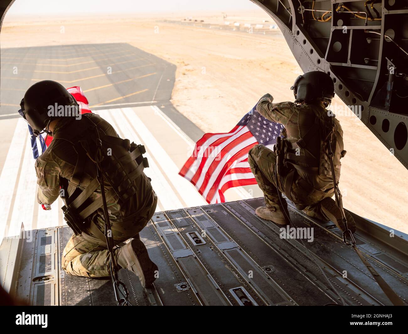 Zwei Mitglieder der Flight Crew von B Co. 640. ASB fliegen amerikanische Flaggen während eines Orientierungsfluges auf einem CH-47 Chinook, während sie mit der 40. CAB nach Camp Buehring, Kuwait, zur Unterstützung der Operation Inhärent Resolve eingesetzt werden. | US Army National Guard Foto von 2LT. Kyle Gallagher Stockfoto