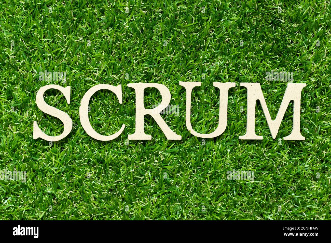 Holzbuchstabe im Wort Scrum auf grünem Gras Hintergrund Stockfoto