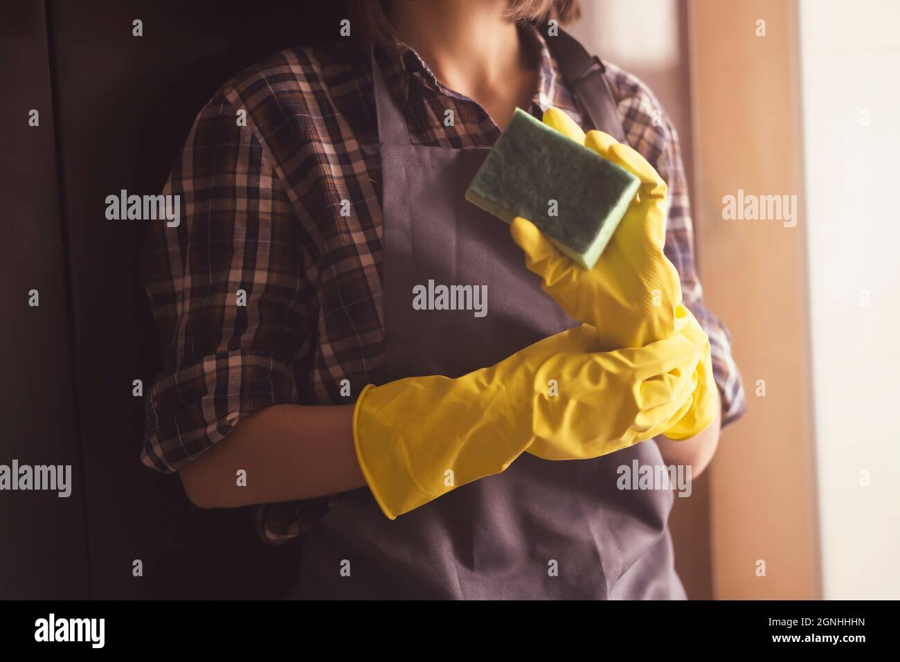 Eine Frau in gelben Gummihandschuhen macht Hausarbeit Stockfoto
