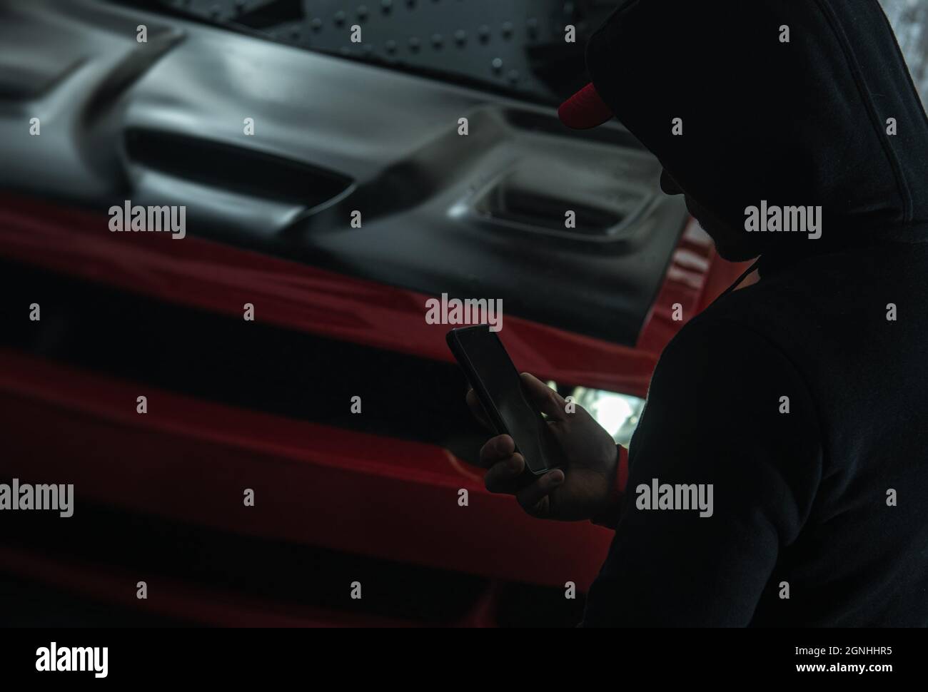 Illegal Night Time Street Racing Theme. Männer mit Hoodie rufen andere Rennteilnehmer an Stockfoto