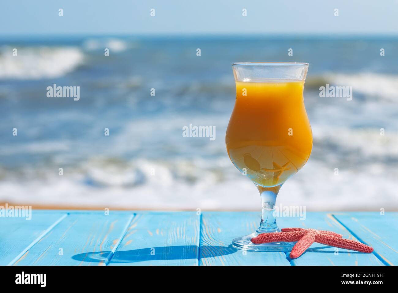 Ein Glas Mangosaft auf dem Tisch am Strand Stockfoto