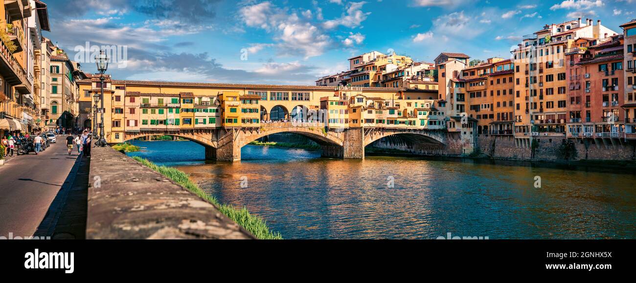 Panoramablick auf die mittelalterliche gewölbte Flussbrücke mit römischen Ursprüngen - Ponte Vecchio über den Fluss Arno. Bunte sommerliche Stadtansicht von Florenz, Italien, Europ Stockfoto