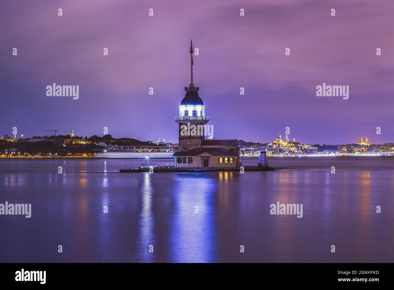 Maiden-Turm, 'kiz Kulesi' in der Nacht, lange Sicht von Üsküdar-Istanbul und eine schöne Spiegelung seiner Lichter auf dem Marmarameer Bosporus. Stockfoto