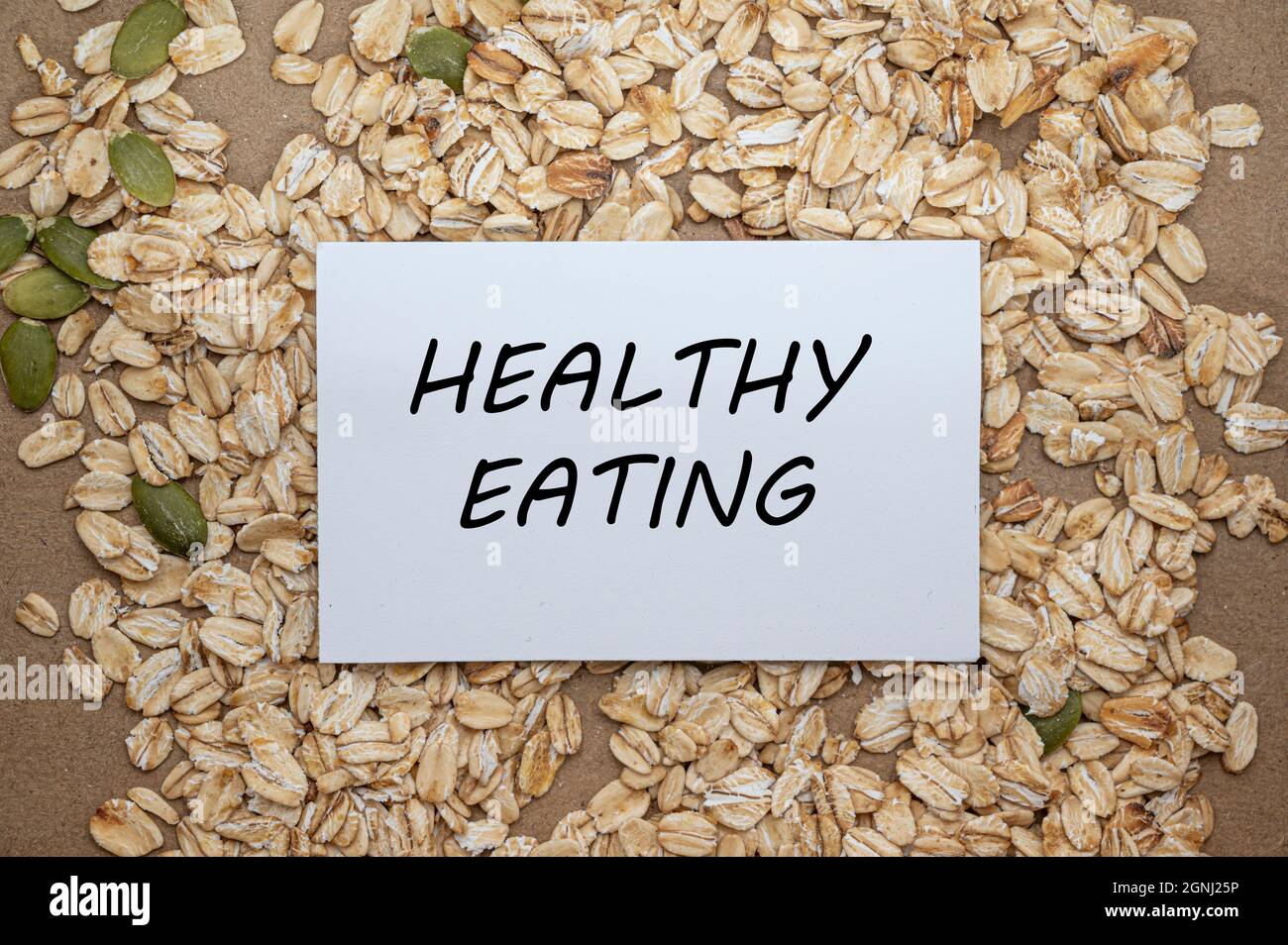 Gesunde Ernährung Konzept. Draufsicht der Karte mit Text gesunde Ernährung auf Hafer und Samen Hintergrund. Stockfoto