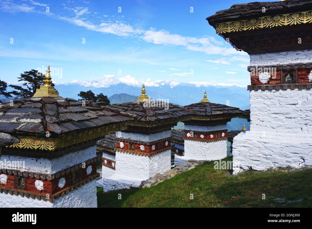 Blick vorbei an den Druk Wangyal Chortens am Dochula Pass in Bhutan, auf der Straße von Thimphu nach Punakha, zu den schneebedeckten Himalaya-Bergen dahinter Stockfoto