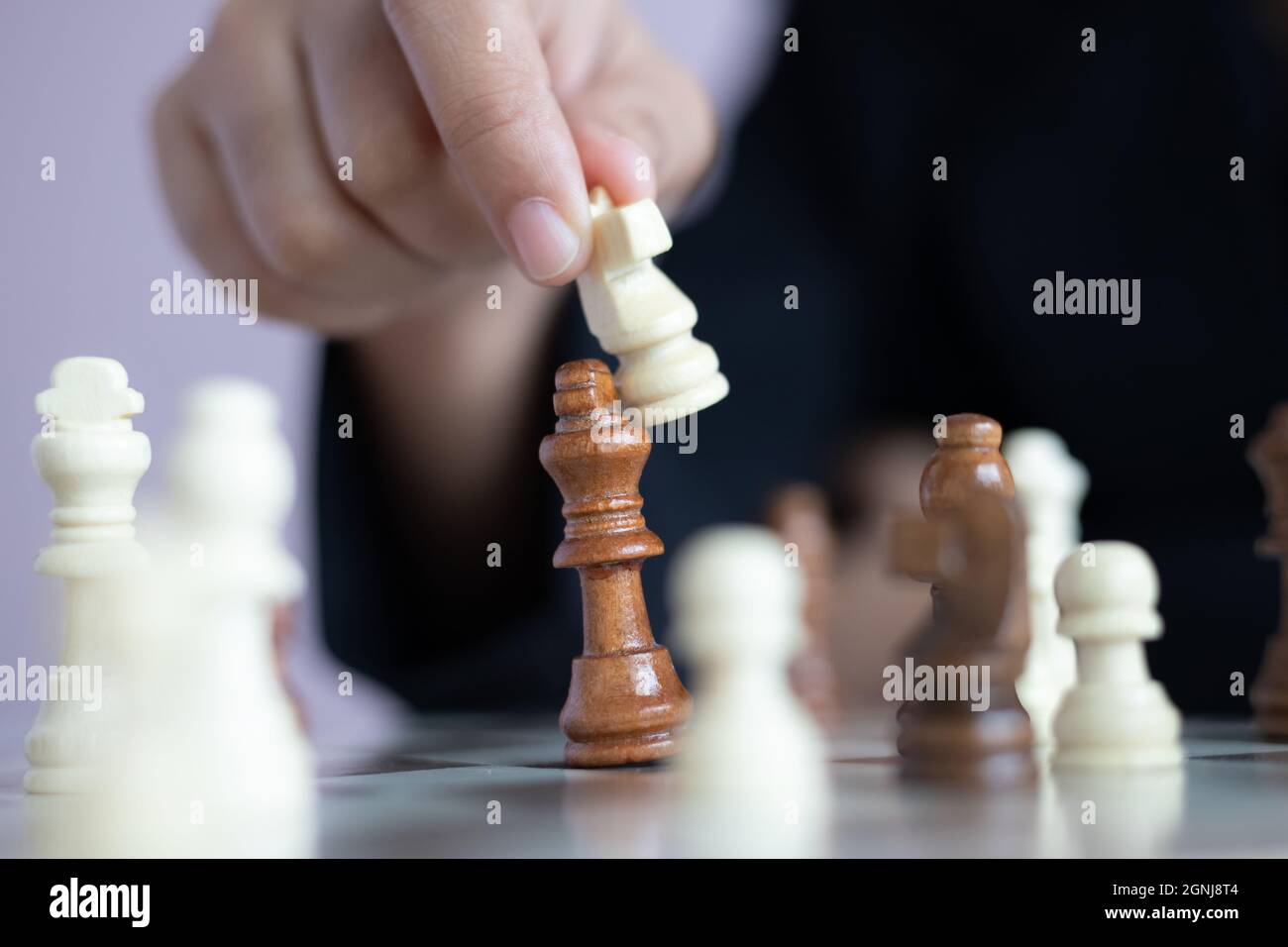 Nahaufnahme der Hand des Business woman Spielen auf dem Schachbrett durch das Töten der König des Gegners Metapher business Wettbewerb Gewinner und Verlierer sel zu gewinnen. Stockfoto