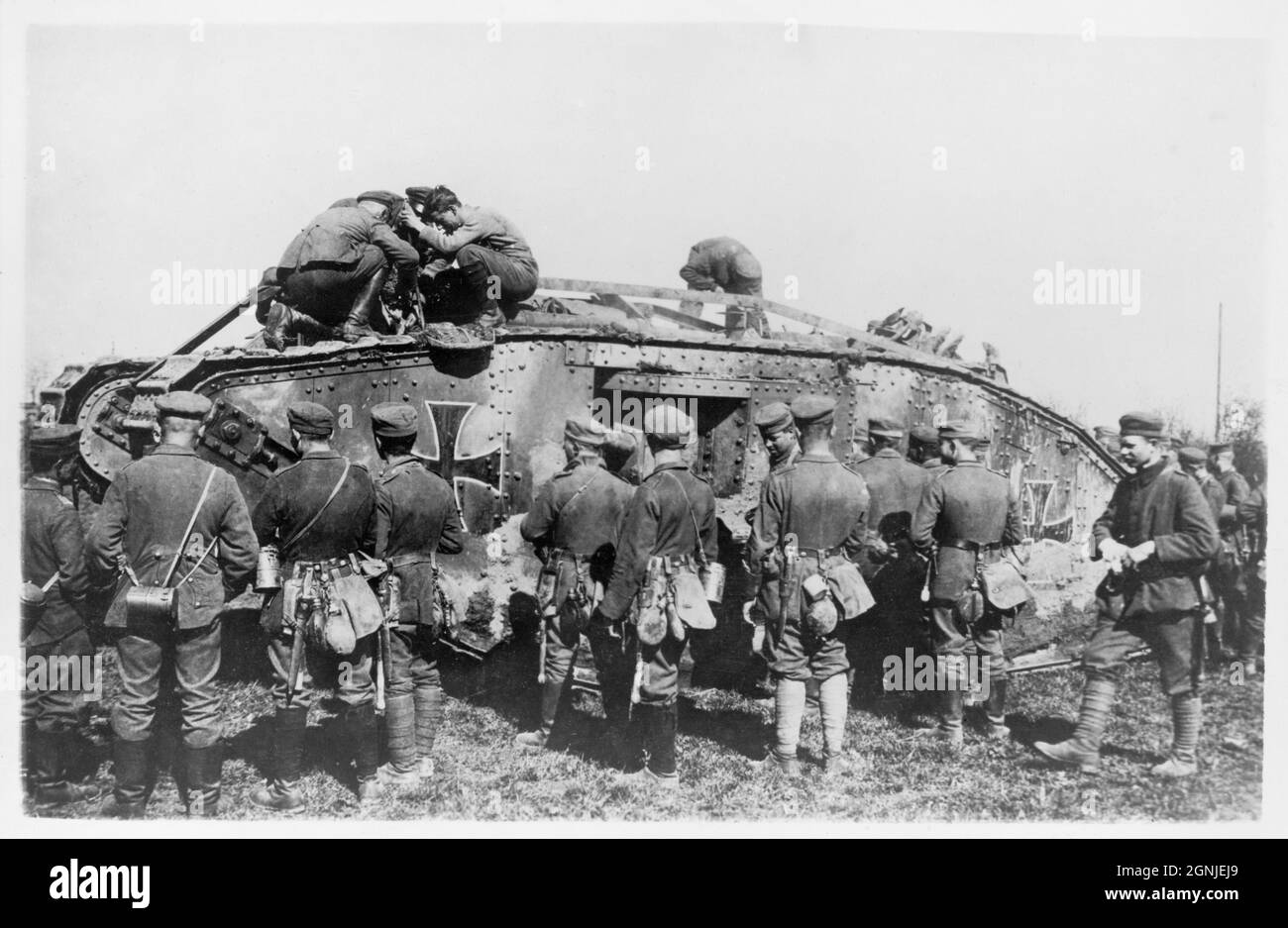 Ein Vintage-Foto von ca. 1918 deutschen Soldaten, die an einem gefangenen britischen Panzer arbeiteten, der mit den deutsch-maltesischen Kreuzmarkierungen neu gestrichen und an der Westfront in Frankreich in den deutschen Militärdienst gebracht wurde Stockfoto