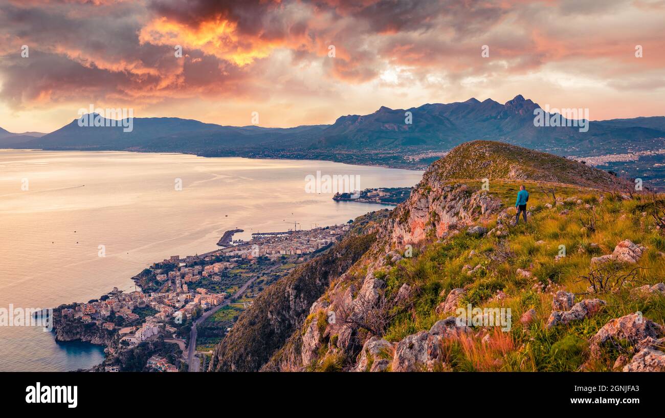 Tourist bewundert von Sonnenaufgang auf hohen Klippen am Ufer des Mittelmeers. Morgenansicht der Stadt Bagheria und Nationalpark Orientata Pizzo Cane, Pizz Stockfoto