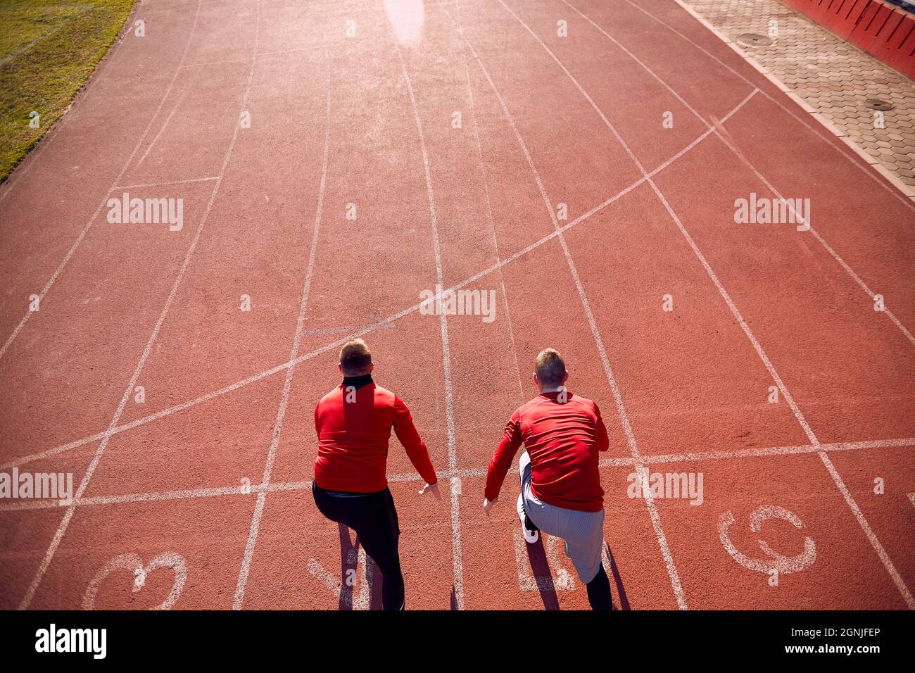 An einem schönen Tag im Stadion fahren zwei junge Männer bei einem sportlichen Training. Sport, Leichtathletik, Sportler Stockfoto