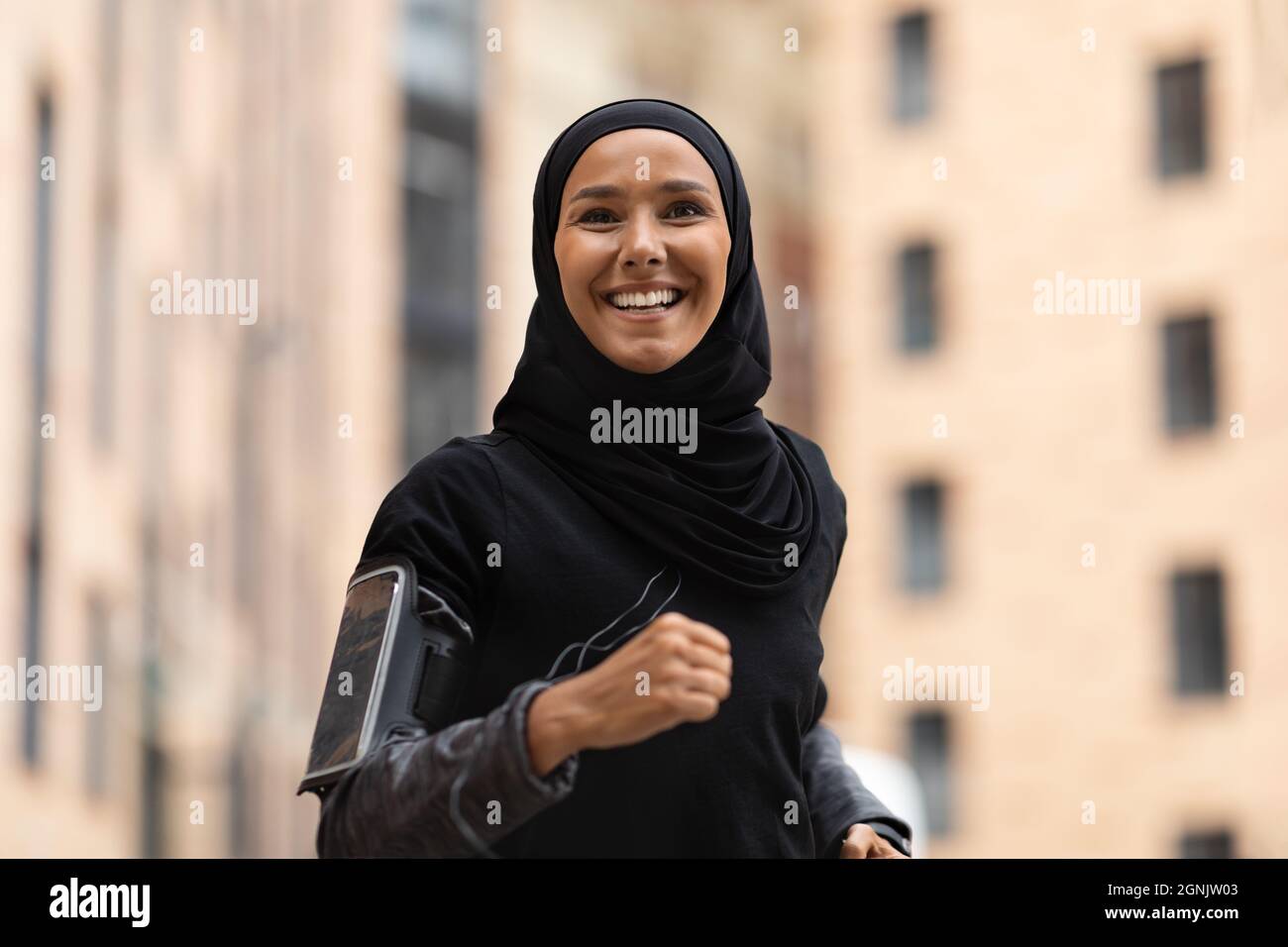 Porträt Einer Glücklichen Jungen Islamischen Dame In Hijab Beim Joggen Im Freien Stockfoto