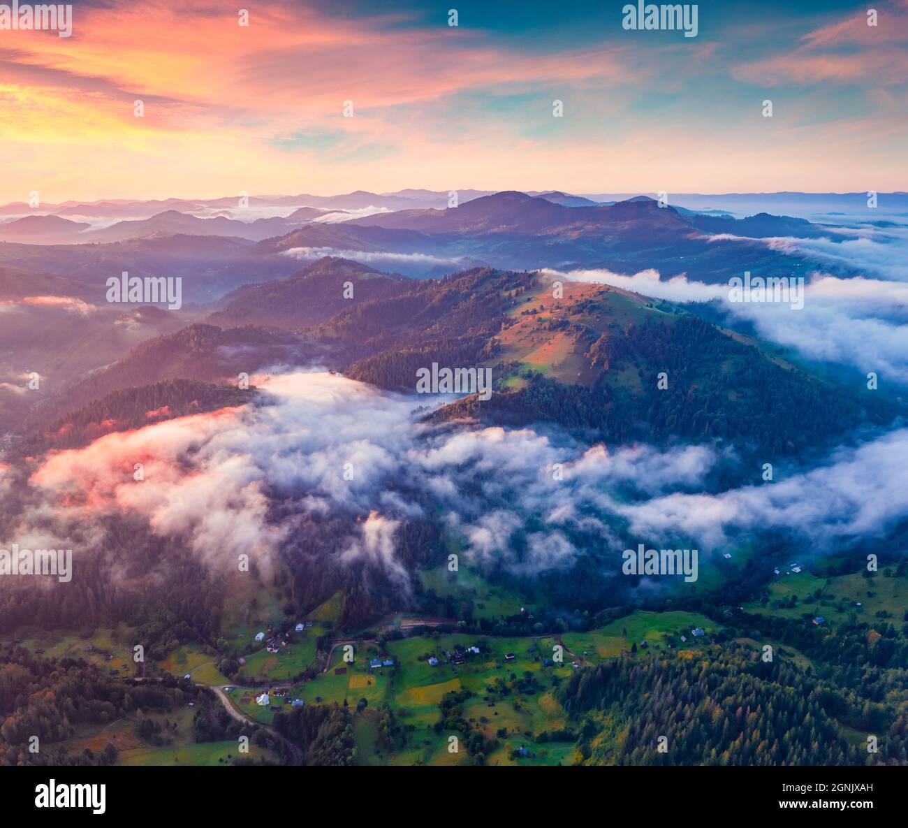 Wunderschöne Sommerlandschaft. Fantastischer Sonnenaufgang auf den Karpaten. Nebel breitet sich im Tal des Dorfes Snidavka, Ukraine, Europa aus. Wundervolle Landschaft Stockfoto