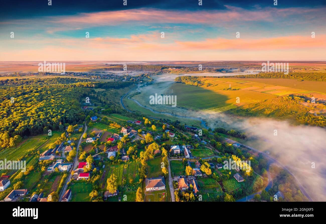 Landschaftsaufnahmen aus der Luft. Atemberaubende Sommeransicht von fliegender Drohne auf die ukrainische Landschaft mit nebligen Fluss. Unglaublicher Sonnenaufgang am Stadtrand von Ter Stockfoto
