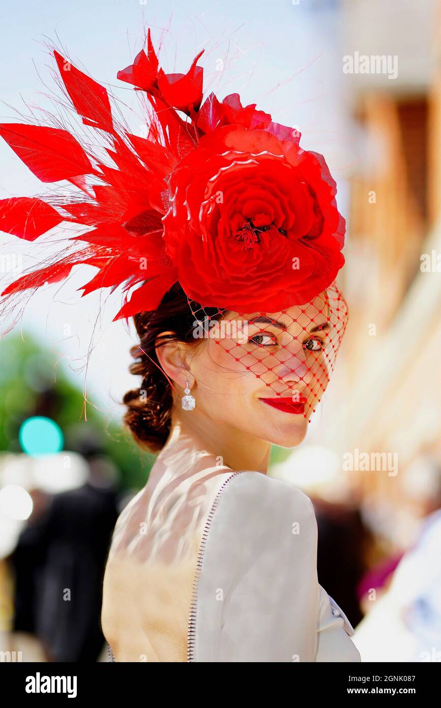 Eine elegante Dame zeigt am Ladiesday ihren edlen roten Hut mit Schleier Stockfoto