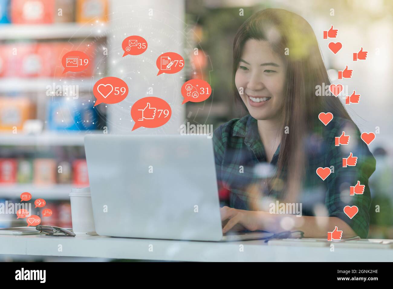 Asiatische Frau Hand mit Laptop, um Social-Network-Anwendung mit der Anzahl der Like überprüfen, Liebe, Kommentar, Menschen und fovorite Symbol am Schreibtisch neben Glas in Stockfoto