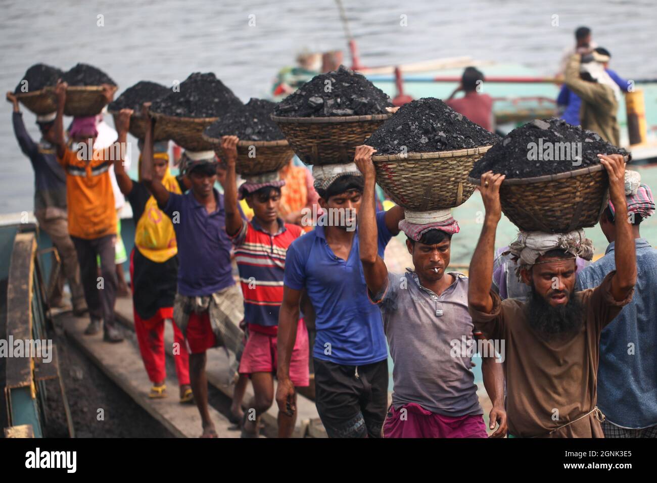 Bangladeschische Arbeitskräfte, die am 16. Februar 2020 Kohle beim Entladen eines Trawlers im turag-Fluss in Dhaka kohlten. Stockfoto