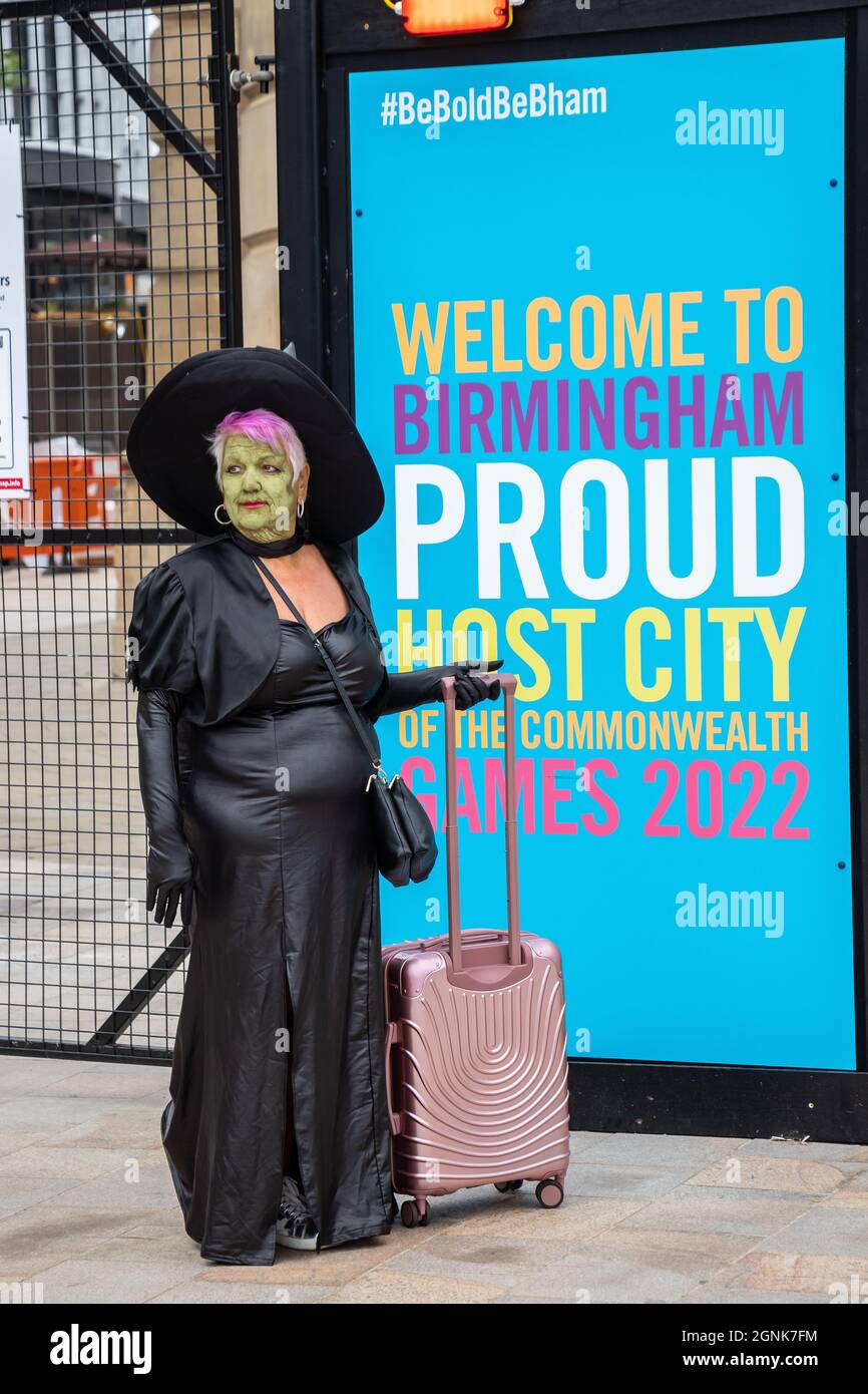 Frau mit Koffer gekleidet als böse Hexe aus Zauberer von oz vor stolzen Stadtschild in Birmingham Pride Samstag, 25. September 2021 Stockfoto
