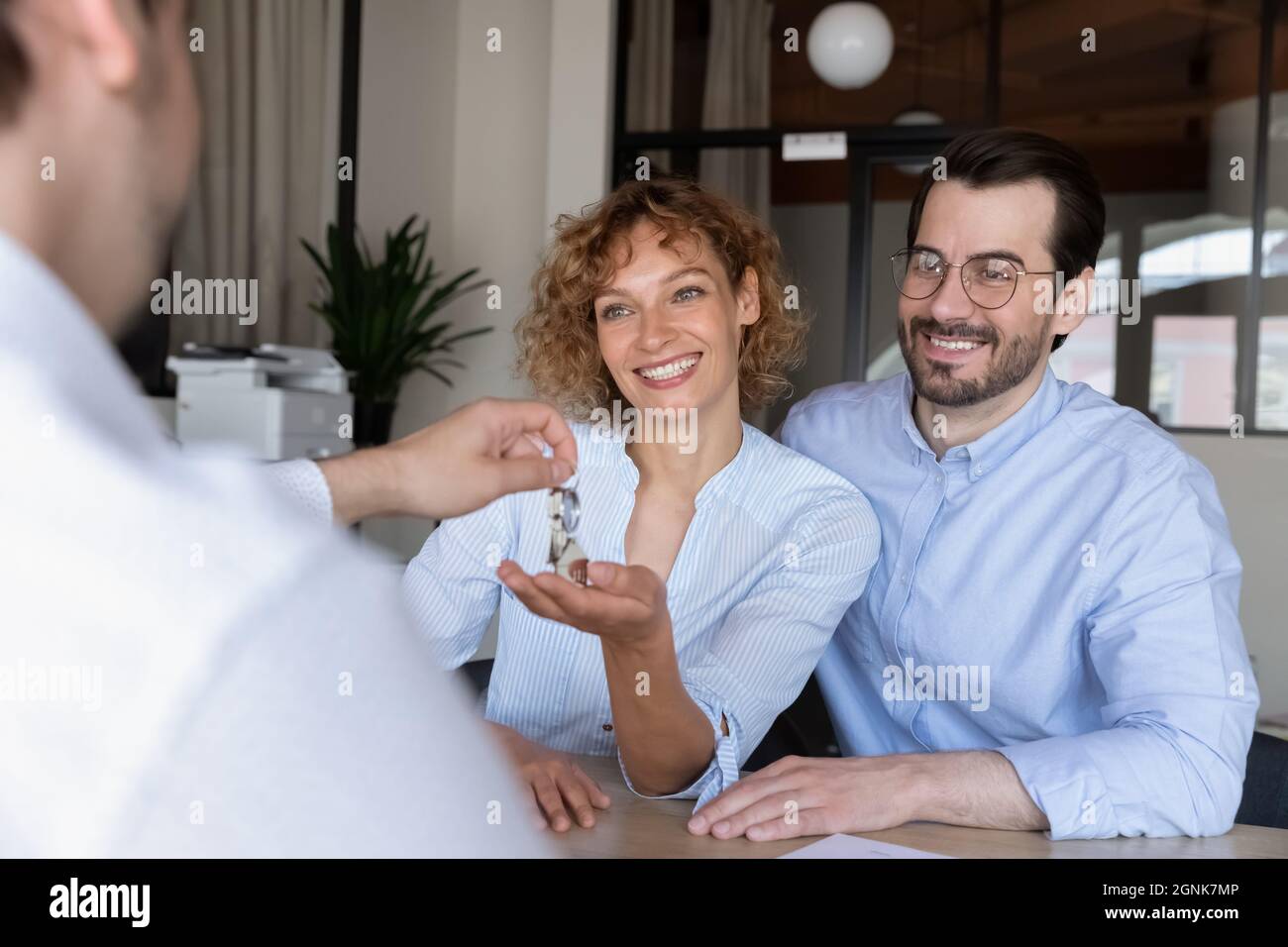 Immobilienmakler geben Schlüssel zu glücklichen Familie paar Kunden Stockfoto