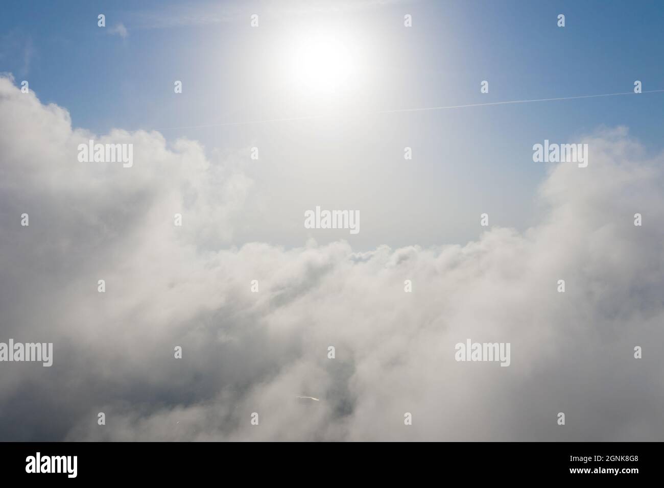 Luftaufnahme von weißen, flauschigen Wolken und etwas blauem Himmel in der Ferne, während sie über Wolken fliegen. Wunderschöne Cumuluswolken, die von einer Drohne eingefangen wurden. Antennenrückstand Stockfoto