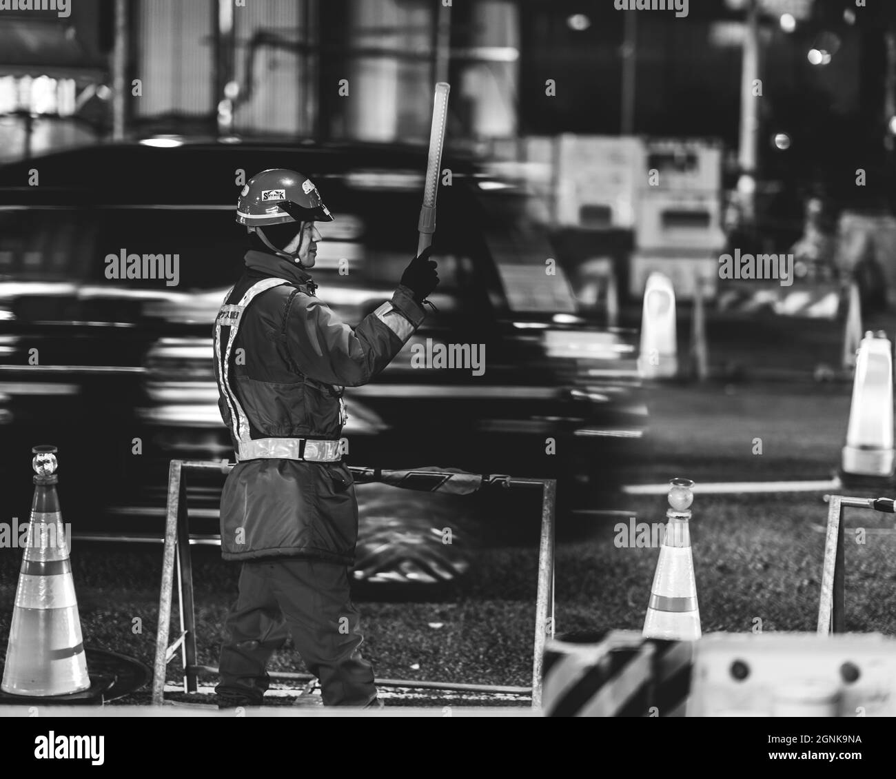 Mann, der den Verkehr wegen der Arbeit auf der Straße mit Bewegung in Japan verwaltet Stockfoto
