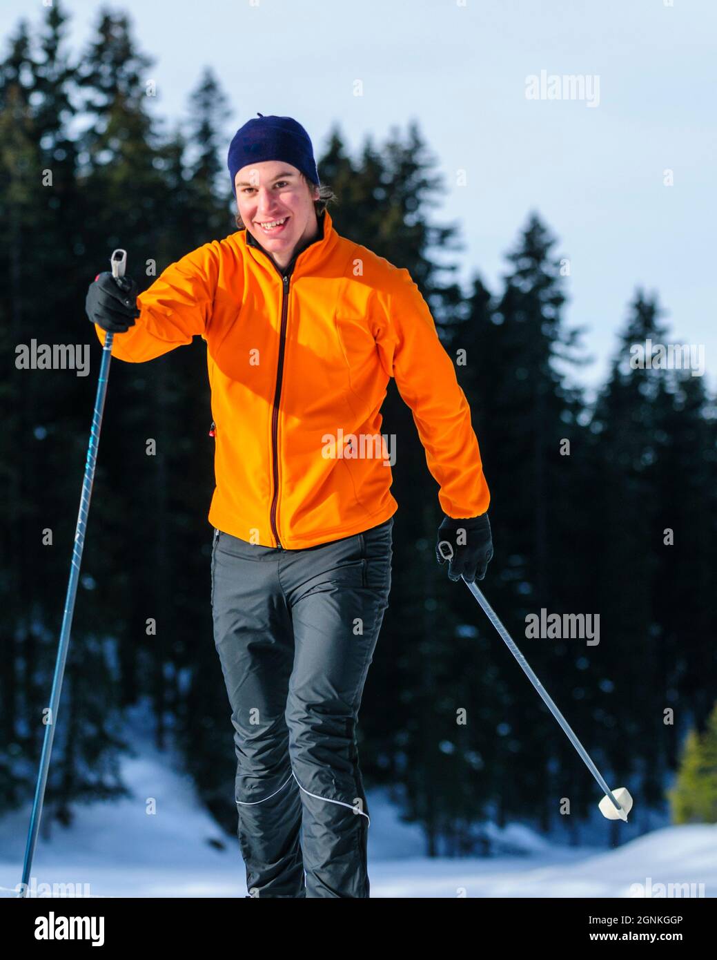 Junger Skifahrer, der an einem sonnigen Wintertag Langlauftraining macht Stockfoto