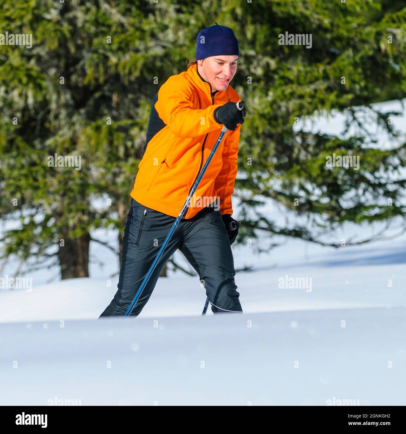 Junger Skifahrer, der an einem sonnigen Wintertag Langlauftraining macht Stockfoto