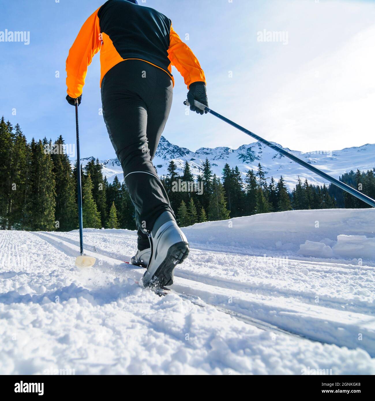 Junger Skifahrer, der an einem sonnigen Wintertag Langlauftraining macht Stockfoto