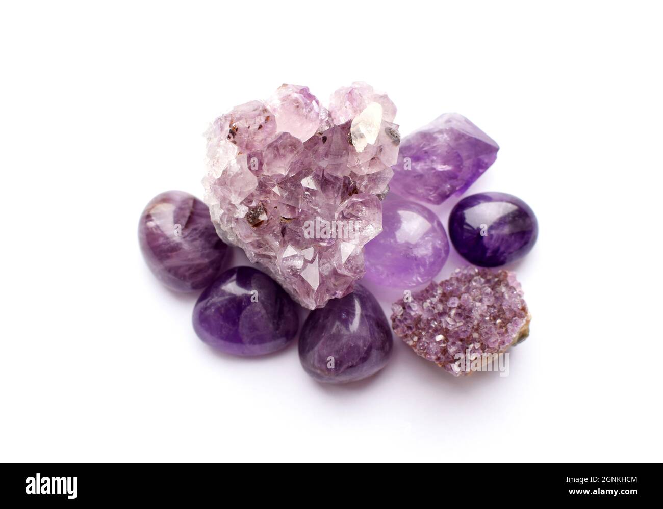 Wunderschöne Edelsteine und Druse aus natürlichem purpurfarbenem Amethyst auf weißem Grund. Große Kristalle aus Halbedelsteinen. Stockfoto