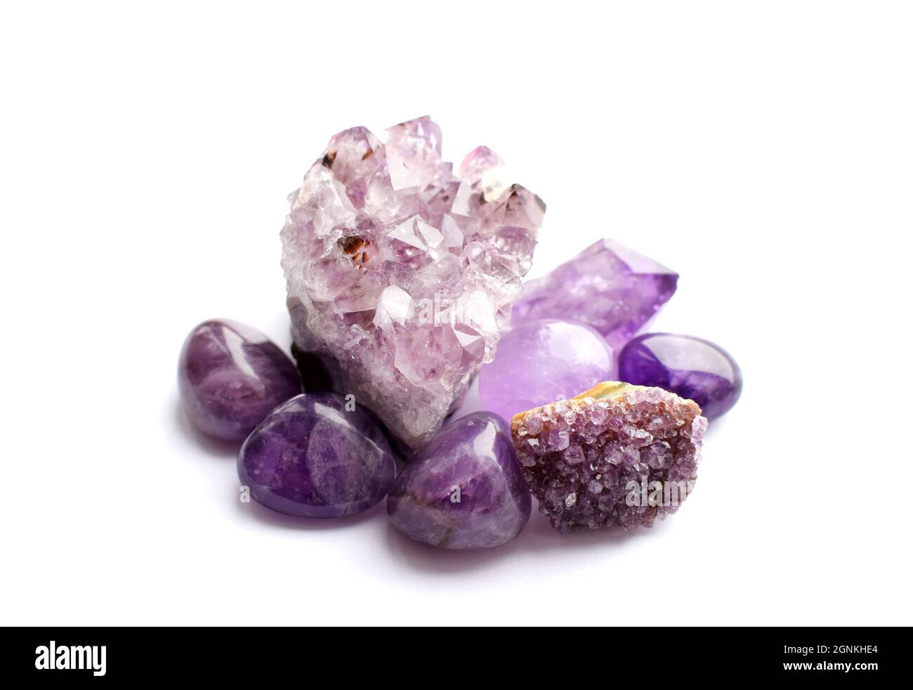 Wunderschöne Edelsteine und Druse aus natürlichem purpurfarbenem Amethyst auf weißem Grund. Große Kristalle aus Halbedelsteinen. Stockfoto