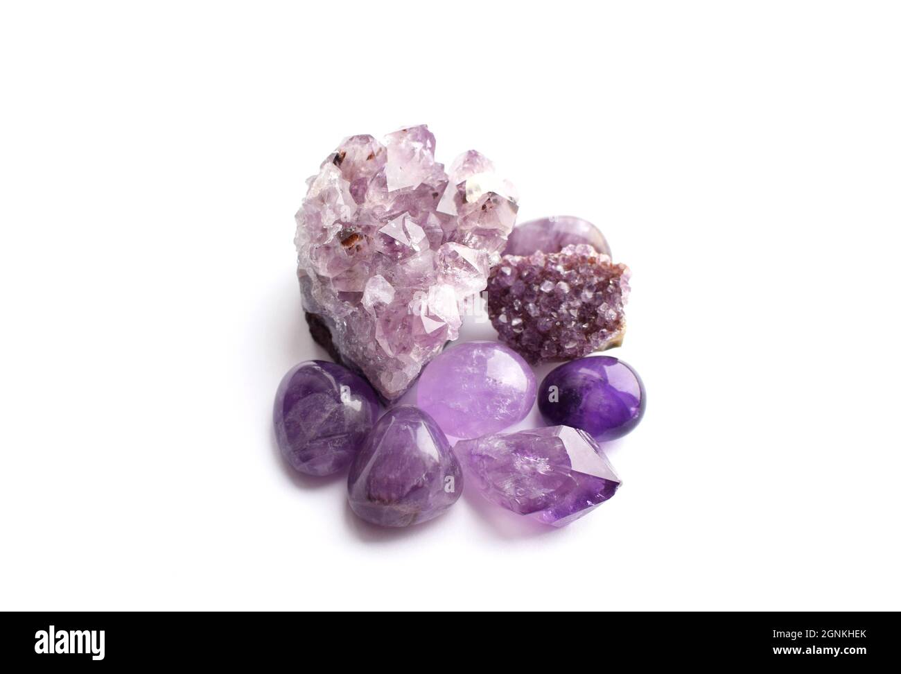 Wunderschöne Edelsteine und Druse aus natürlichem purpurfarbenem Amethyst auf weißem Grund. Große Kristalle aus Halbedelsteinen. Stockfoto