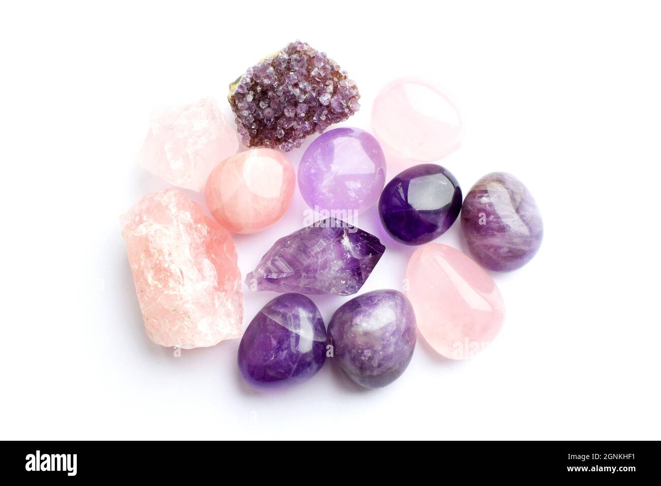 Wunderschöne Edelsteine und Druse aus natürlichem purpurfarbenem Amethyst auf weißem Grund. Amethysten und Rosenquarz. Große Kristalle aus Halbedelsteinen st Stockfoto