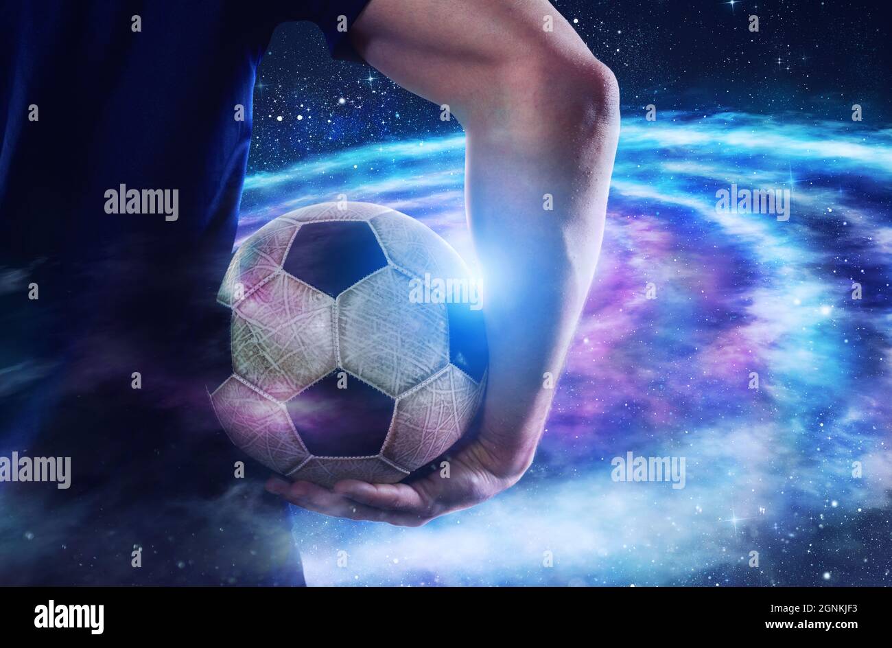 Fußballspieler hält den Ball im Universum Stockfoto