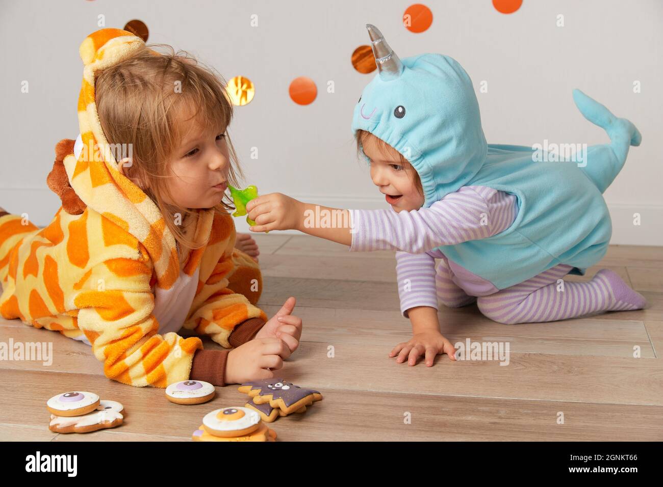 Niedliche kleine Mädchen in Giraffe und Narwhal Kostüm spielen zu Hause. Halloween-Party Stockfoto