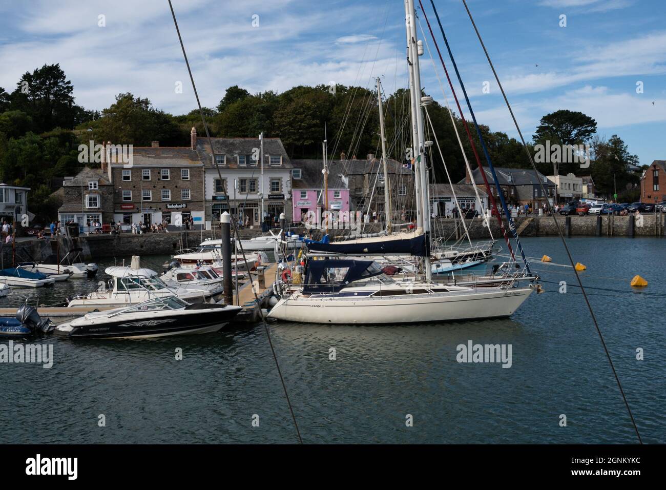 Segelboote, die im malerischen Hafen von Cornwall mit farbenfrohen Gebäuden am Wasser vor Anker liegen Stockfoto