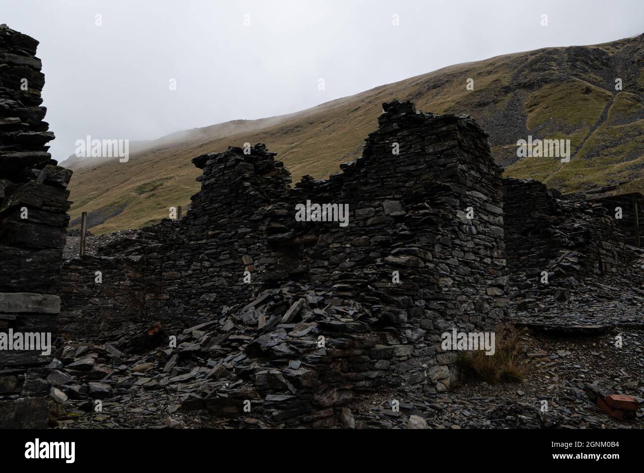 Ruinen von Steinbauten in nebeliger walisischer Berglandschaft Stockfoto