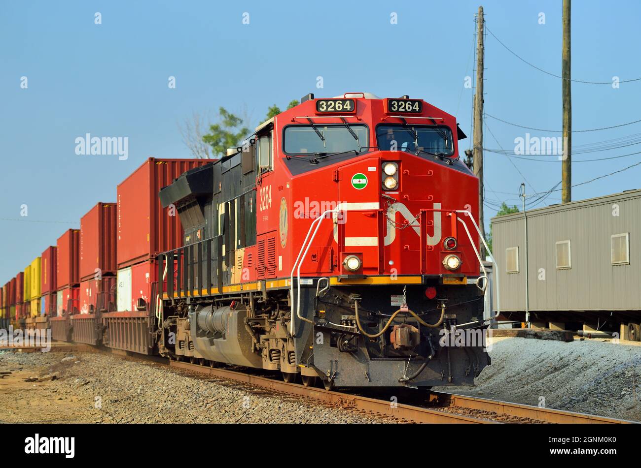 Bartlett, Illinois, USA. Eine einzige Canadian National Railway Lokomotive führt einen intermodalen Güterzug durch eine Kreuzung. Stockfoto