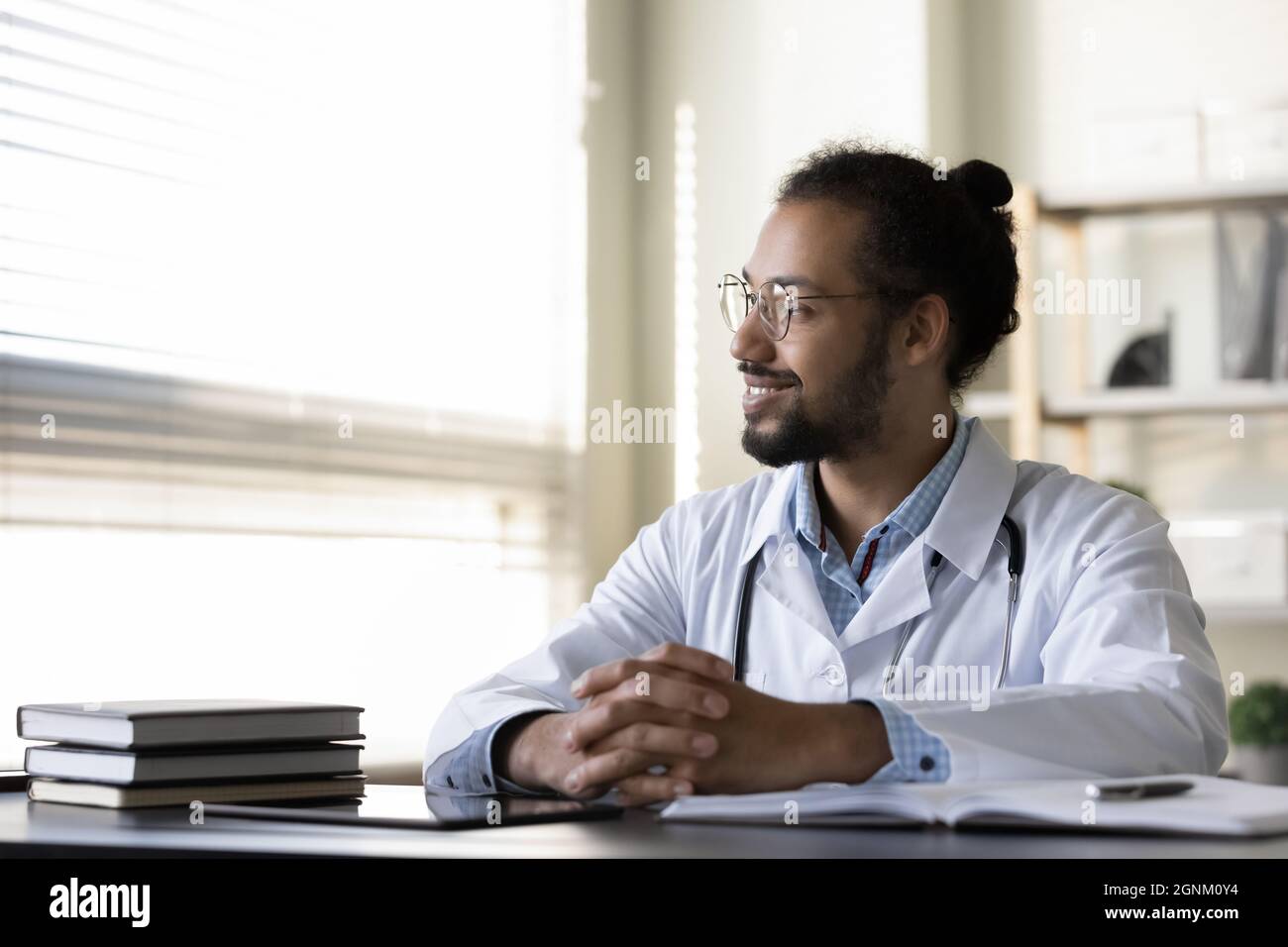 Porträt eines glücklichen jungen Arztes am Arbeitsplatz Stockfoto