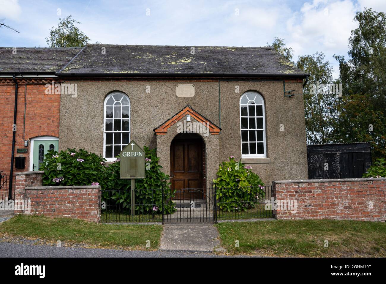 Historische Kapelle mit Bogenfenstern und Ziegelmauer im walisischen Dorf Stockfoto