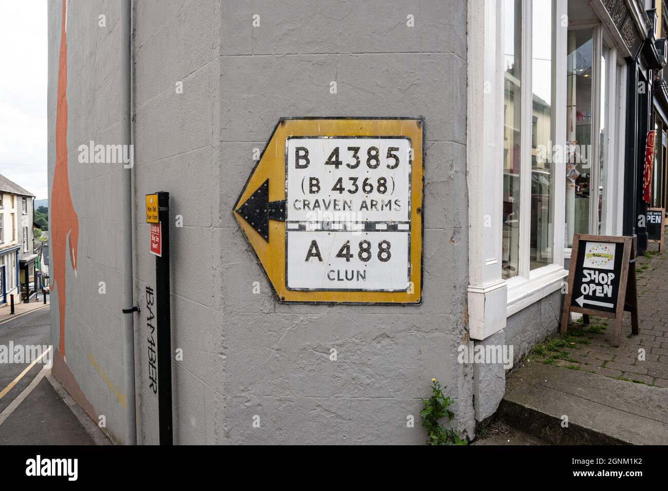 Walisisches Straßenschild mit Wegbeschreibung nach Craven Arms und Clun an der Stadtmauer Stockfoto