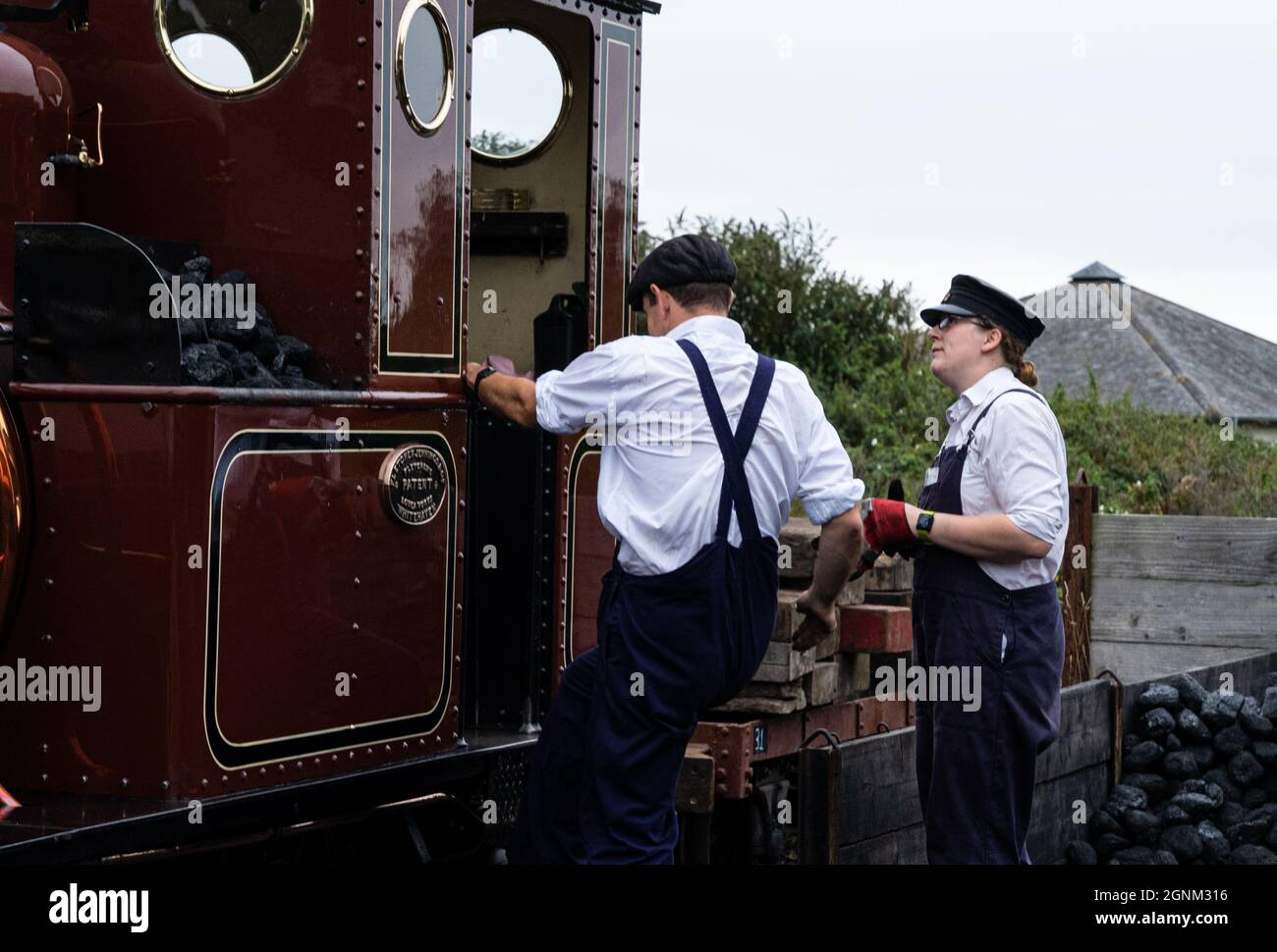 Dampflokomotivbesatzung beim Verladen von Kohle am historischen Bahnhof Stockfoto